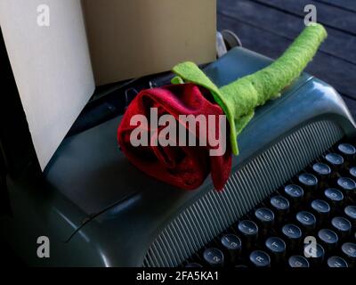 Une rose sur une pile de livres et une machine à écrire Banque D'Images