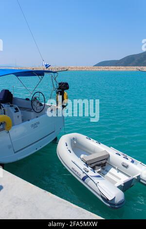 Vasiliki, Grèce - juillet 25 2019: Photographie de voyage, mer turquoise, bateaux, vieille place avec montagnes, drapeau bleu blanc de la grèce Banque D'Images