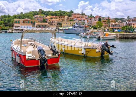 Île de Corfou/Grèce - 6 mai 2019 : vue sur le magnifique village de Kassiopi - lagune de mer avec eau turquoise calme, bateaux colorés, maisons et café de rue sur Banque D'Images