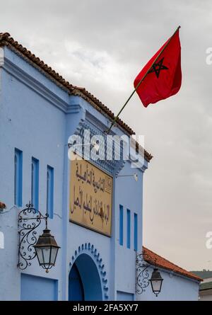 Une photo du Lycée Imam El Chadili avec le drapeau marocain qui agite dans l'air. Banque D'Images