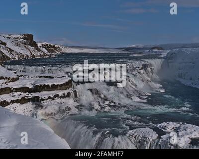 Vue imprenable sur la cascade supérieure de la cascade de Gullfoss dans le sud-ouest de l'Islande, partie du célèbre cercle d'or, en hiver avec un arc-en-ciel clair. Banque D'Images