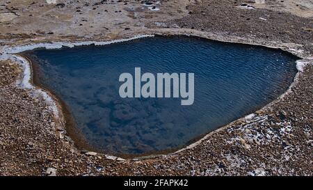 Source chaude avec piscine d'eau thermale claire et bleue chatoyante à Geysir dans la zone géothermique Haukadalur, une partie du cercle d'or, en Islande en hiver. Banque D'Images