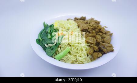 Mie ayam, mi ayam ou bakmi ayam peut être un plat indonésien commun de nouilles de blé jaune préparées et garnies de viande de poulet en dés. Banque D'Images