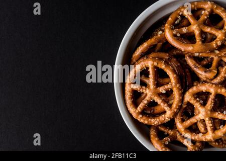 Vue de dessus de bretzels salés dans le bol avec noir arrière-plan Banque D'Images