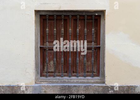 Fenêtre vintage avec grille en fer sur un mur en pierre. Valence, Espagne Banque D'Images