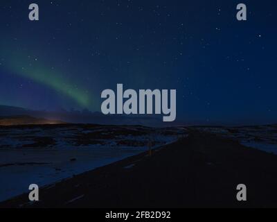 Belle lumière verte chatoyante du nord (aurora borealis) dans le ciel sombre et étoilé au-dessus de la péninsule de Snæfellsnes, à l'ouest de l'Islande en hiver. Banque D'Images