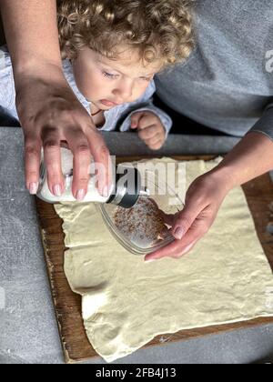 maman et fils préparent la garniture pour les petits pains Banque D'Images