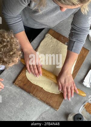 maman et son fils font des petits pains à partir de la pâte Banque D'Images