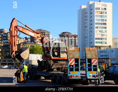 Chargement d'un creuseur mécanique sur une remorque de camion dans le parking du club de football Racing Santander Santander Santander Cantabria Espagne Sunny Spring Morning Banque D'Images