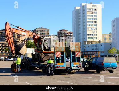 Chargement d'un creuseur mécanique sur une remorque de camion dans le parking du club de football Racing Santander Santander Santander Cantabria Espagne Sunny Spring Morning Banque D'Images