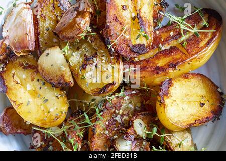 Ragoût appétissant de filet de porc cuit dans le wok, coupé en cubes. Avec pommes de terre rôties et dorées, ail, sel, origan et tomates fraîches. Banque D'Images