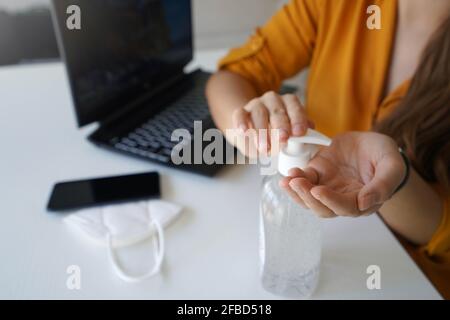 Désinfectant pour les mains. Gros plan de femme d'affaires mains assainissantes avec du gel d'alcool dans le bureau. Banque D'Images