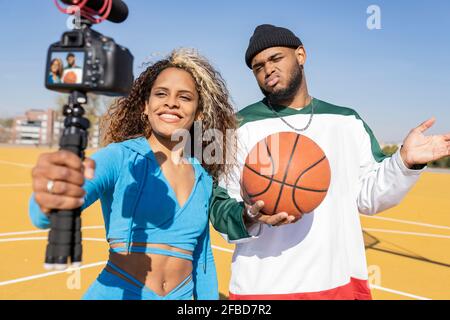 Femme et homme avec vlogging de basket-ball sur le terrain de sport Banque D'Images