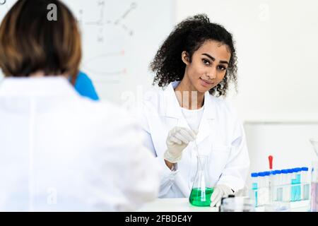 Chercheur souriant travaillant en laboratoire avec un collègue Banque D'Images