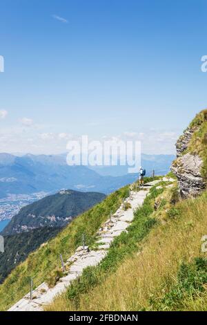 Randonneur expérimenté admirant le paysage environnant depuis le sentier de randonnée au sommet De Monte Generoso Banque D'Images