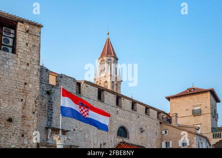 Croatie, Comté de Split-Dalmatie, Trogir, drapeau croate suspendu devant les maisons de la vieille ville avec clocher de l'église Saint Nicolas en arrière-plan Banque D'Images