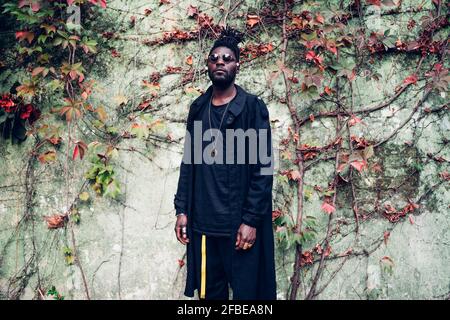 Jeune homme à la mode debout devant le mur Banque D'Images