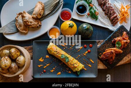 Cannelloni, pâtisseries, pommes de terre, viande et ailes de poulet servis au restaurant Banque D'Images