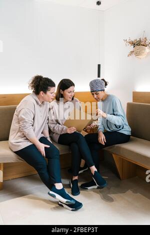 Équipe de dentistes discutant du dossier tout en étant assis sur un canapé à la clinique Banque D'Images