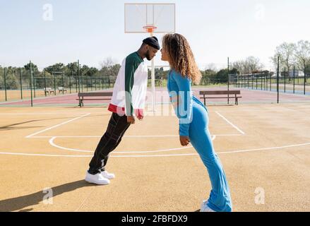 Des amis masculins et féminins se penchent sur un terrain de basket-ball Banque D'Images
