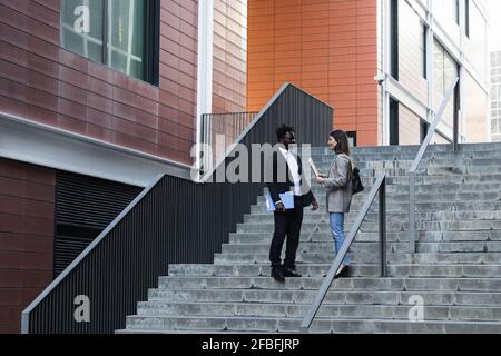 Les gens d'affaires parlent en se tenant sur l'escalier Banque D'Images