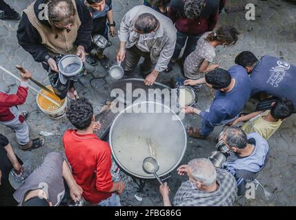 Gaza, Palestine. 23 avril 2021. Le palestinien Walid Al-Hattab (portant une chemise à carreaux) distribue gratuitement de la nourriture aux familles pauvres pendant le mois Saint du Ramadan dans le quartier de Shejaiya à Gaza. (Photo de Yousef Masoud/SOPA Images/Sipa USA) crédit: SIPA USA/Alay Live News Banque D'Images