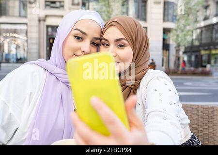 Femme arabe qui prend le selfie par téléphone intelligent en ville Banque D'Images