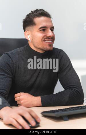 Souriant homme entrepreneur en utilisant la souris d'ordinateur sur le bureau au travail placer Banque D'Images