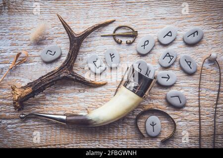 Vue plate sur les pierres d'rune avec divers objets de style de l'ère viking. Concept de style de vie ancestral de divination et de vikings. Banque D'Images