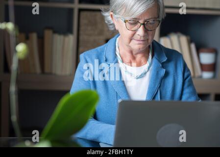 Femme d'affaires concentrée travaillant sur un ordinateur portable au bureau à domicile Banque D'Images