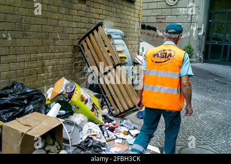 Employé du service municipal de nettoyage au travail dans une rue sale, Naples, Italie Banque D'Images