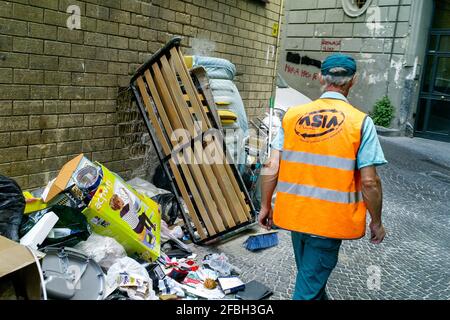 Employé du service municipal de nettoyage au travail dans une rue sale, Naples, Italie Banque D'Images