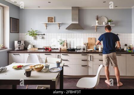 Homme mature préparant des aliments dans la cuisine à la maison Banque D'Images