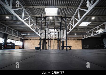 Anneaux et cordes de gymnastique suspendus dans la salle de gym vide Banque D'Images