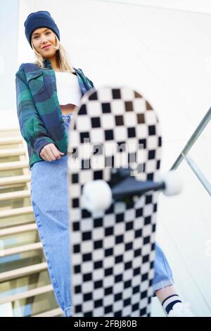 Jeune femme qui fait des cascades sur un skateboard Banque D'Images