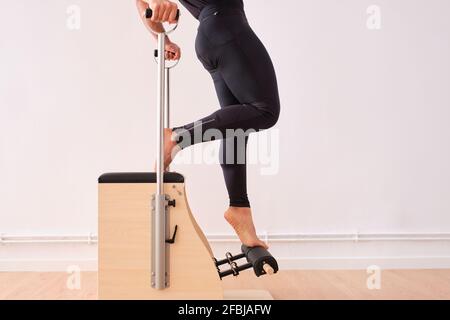 Homme étirant les jambes tout en faisant des pilates dans la salle d'exercice Banque D'Images