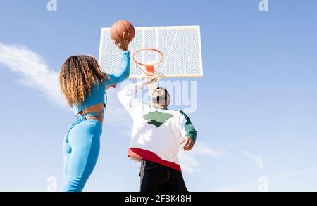 Hommes et femmes jouant au basket-ball sur le terrain de sport Banque D'Images
