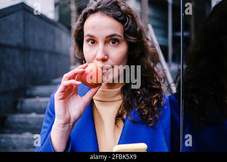 Belle femme professionnelle mangeant de la pomme fraîche Banque D'Images