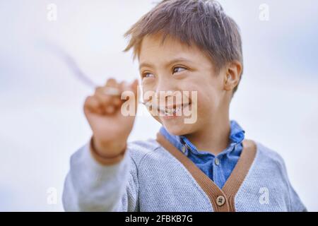 Garçon avec le bâton de morsure de syndrome de Down Banque D'Images