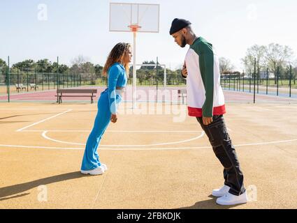 Des hommes actifs et des amis se penchent sur un terrain de basket-ball Banque D'Images
