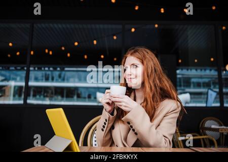 Belle femme prenant un café au café Banque D'Images