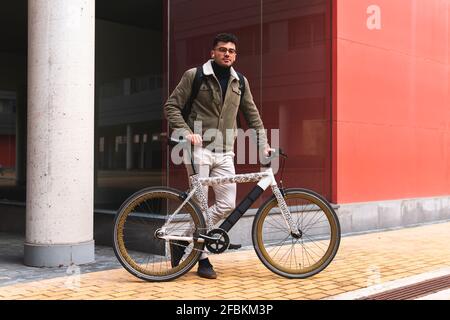Beau homme d'affaires avec vélo debout sur la piste de marche Banque D'Images