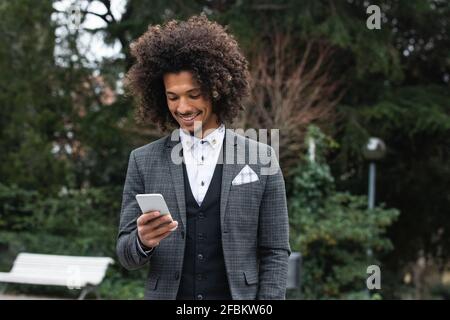 Beau homme d'affaires souriant utilisant un téléphone portable Banque D'Images