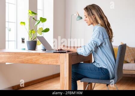 Femme d'affaires concentrée travaillant sur un ordinateur portable au bureau à domicile Banque D'Images