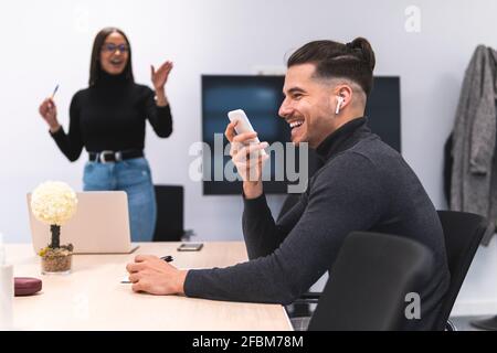 Homme d'affaires souriant parlant sur téléphone portable lors d'une conférence au bureau Banque D'Images