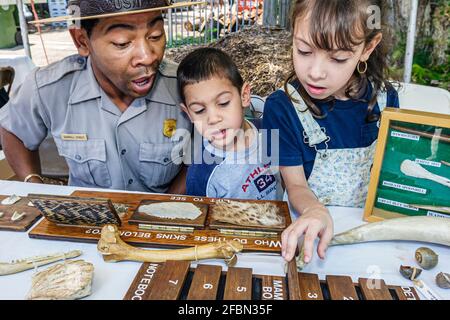 Miami Florida,Little Haiti Earth Day Festival,Everglades National Park ranger expliquer l'enseignement Black man mâle,garçon fille frère soeur exposition exhib Banque D'Images