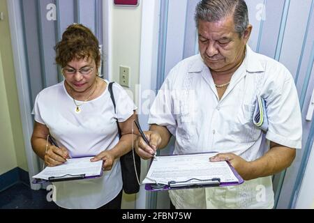 Miami Beach Florida, centre de santé communautaire, hispanique femme homme couple homme femme prise d'une entrevue d'enquête, co de dépistage gratuit Banque D'Images