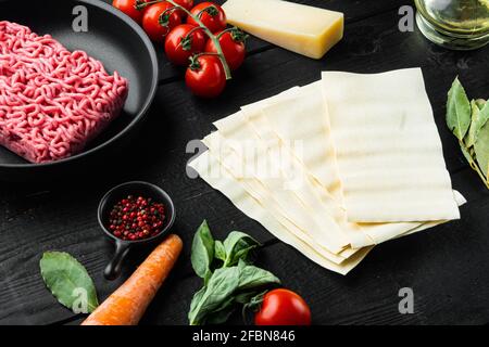 Cuisine italienne aliments cuisine Ingrédients, avec pâtes de Lasagna, fromage parmesan et set de saison, sur fond de table en bois noir Banque D'Images
