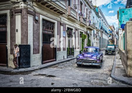 La Havane, Cuba, juillet 2019, vue sur une vieille voiture Chevrolet classique violette passe Casa Martha une maison d'hôtes dans la partie la plus ancienne de la ville Banque D'Images