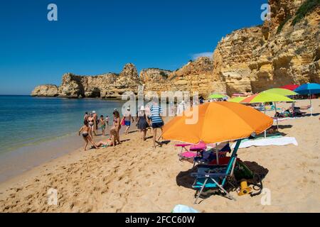 Les jours de plage avec des parasols, des chaises de plage et des personnes profitant du soleil et marchant sur le sable. Praia da Marinha Algarve au Portugal. Belle journée sur la plage. Banque D'Images